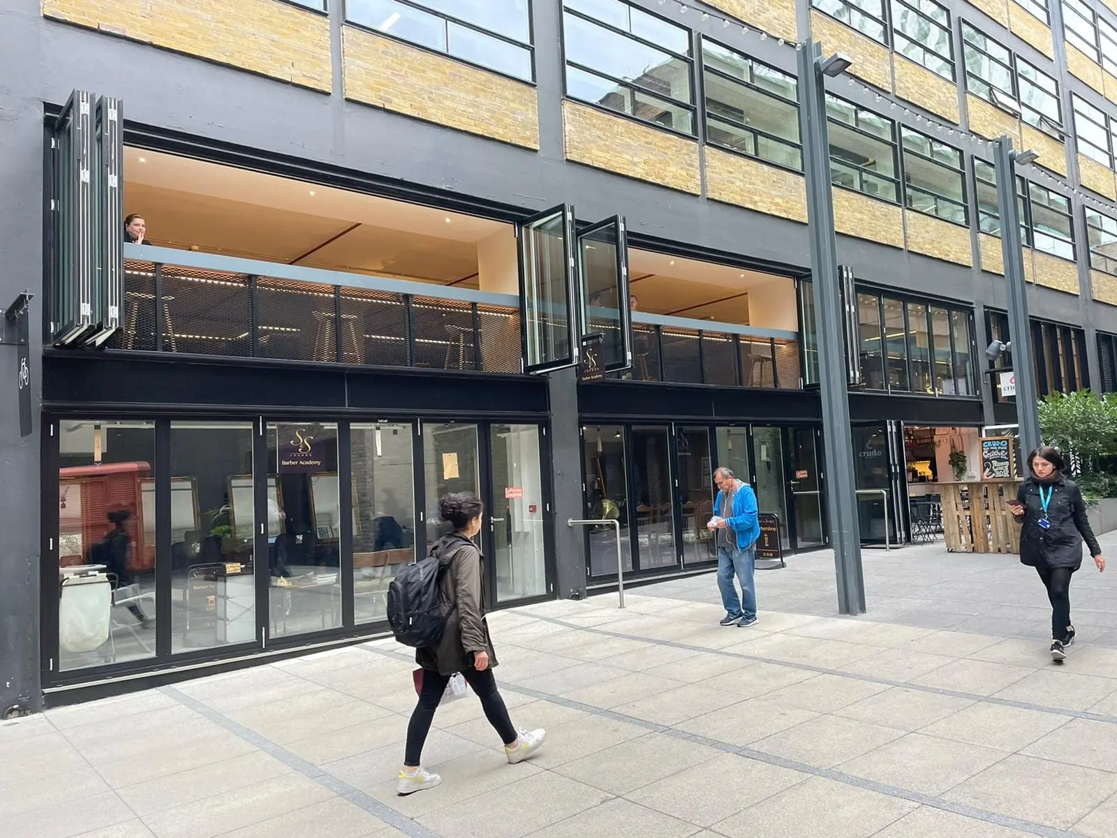 Black aluminium bifold doors on ground-floor commercial units, with folding windows open on the floor above, Blackfriars